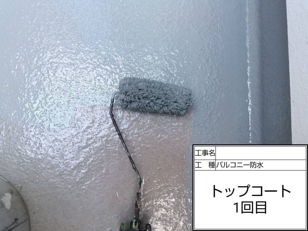 トップコート1回目を施工し、防水層の基盤を形成しました。均一な塗布で防水性と耐候性を高め、雨水から建物を守る役割を担います。