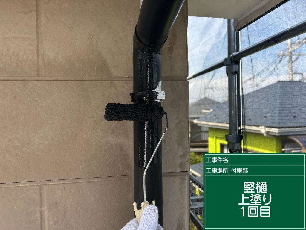 竪樋に1回目の上塗りを施し、塗膜を形成。防水性と美観を兼ね備えた仕上がりに近づけています。