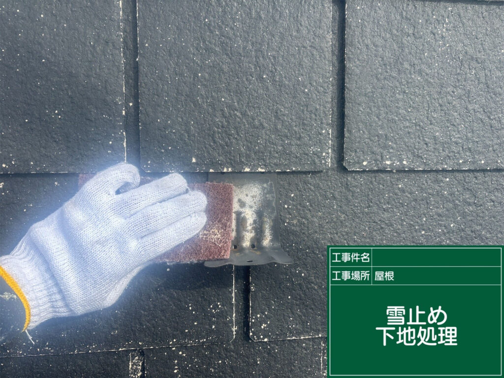 雪止め金具に付着した汚れやサビをケレン作業で丁寧に除去。塗料の密着を高め、耐久性を確保する大切な準備工程です。