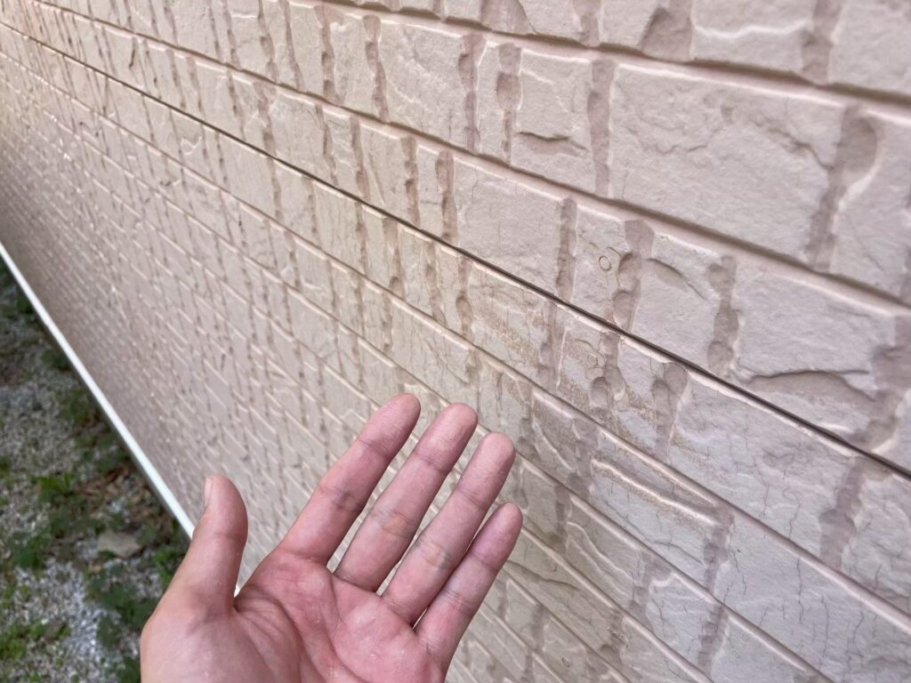 外壁を触ると白い粉が付着するチョーキング現象を確認。塗膜が紫外線により分解され、防水・防汚性能が失われています。