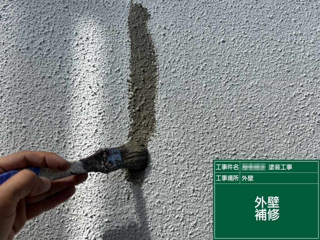 外壁の欠損部分をモルタルで補修中。凹凸を周囲になじませることで、塗装後の仕上がりが美しく整います。