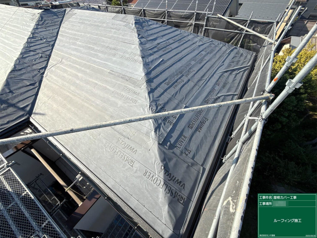 既存屋根の上に防水シート（ルーフィング）を全面敷設。雨漏り防止の要となる層で、重ね幅を均一に丁寧に施工します。