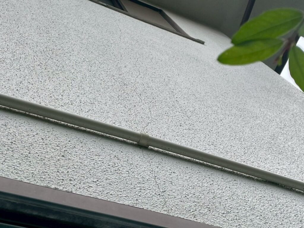 外壁には髪の毛程度のヘアークラックが数箇所ありました。下地処理を丁寧に行い、専用下塗材でひびを埋める補修が必要です。