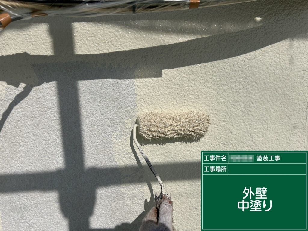 下塗りがしっかり乾燥した後、仕上げ塗料の中塗りを行っています。外壁に適正な膜厚を確保し、耐候性と美観を高めるための重要な工程で、均一に塗り重ねていきます。