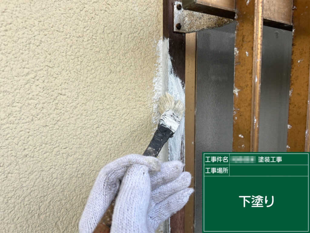 下地処理後、窓枠の素地を保護する下塗り材を刷毛で塗布しています。細かい部分が多いため、ムラを防ぎながら均一に塗り進めることで、仕上がりの品質が大きく向上します。