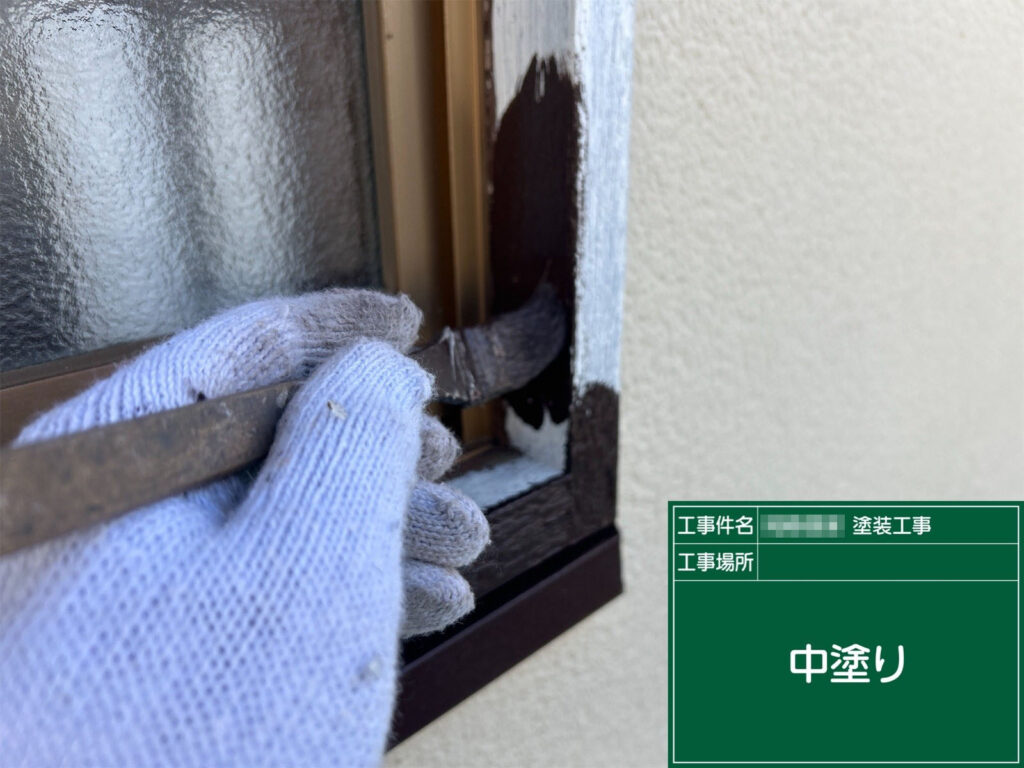 下塗りが乾いた後、窓枠に中塗りを施しています。仕上げ塗料の色と膜厚をしっかり確保し、外壁との調和を考えながら丁寧に塗り重ねています。