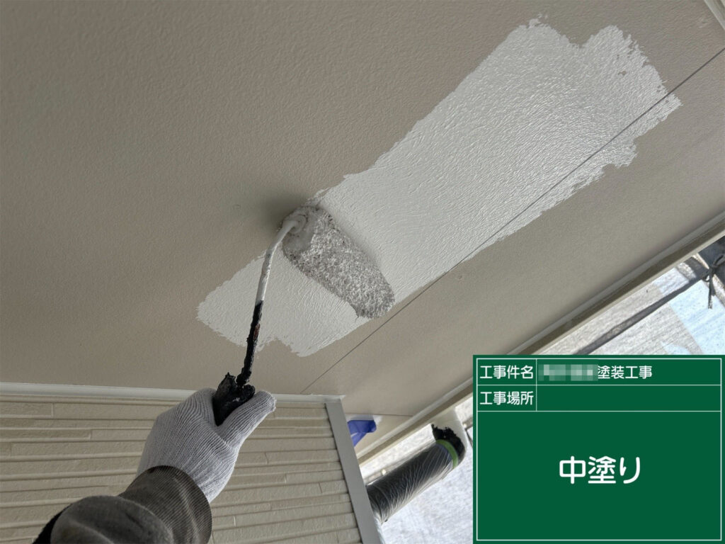 下地処理後、軒天に中塗りを行っています。白色の塗料が均一に乗り、清潔感のある仕上がりに向けた塗膜をしっかり形成しています。