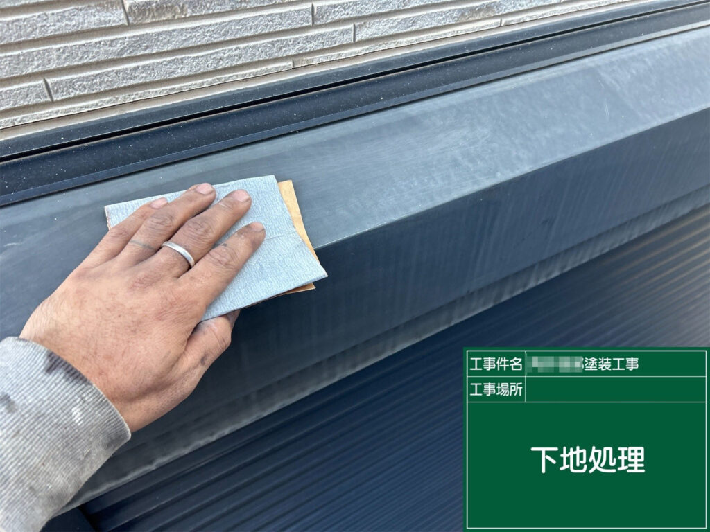 シャッターボックスの表面をサンドペーパーで丁寧に研磨し、汚れや古い塗膜を取り除いています。下地を整えることで、この後の錆止め・上塗りの密着性が大きく向上します。