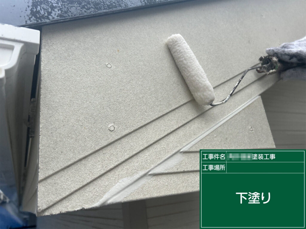 破風板全体に下塗り材を均一に塗布しています。素材の吸い込みを抑え、後の中塗り・上塗りがしっかり密着するよう土台を整える重要な工程です。