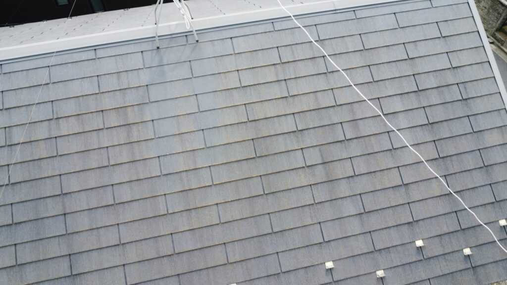 屋根材全体の色褪せが進行し、雨水を吸収しやすい状態となっています。撥水性が失われたことで、コケや汚れが発生しやすい状態でした。