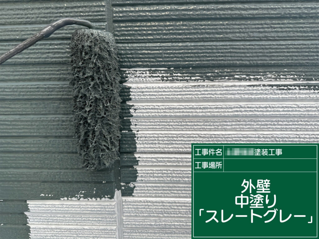 外壁の中塗りを、仕上げ色の「スレートグレー」で施工します。膜厚を確保しながら色ムラを整え、上塗りの仕上がりを安定させます。
