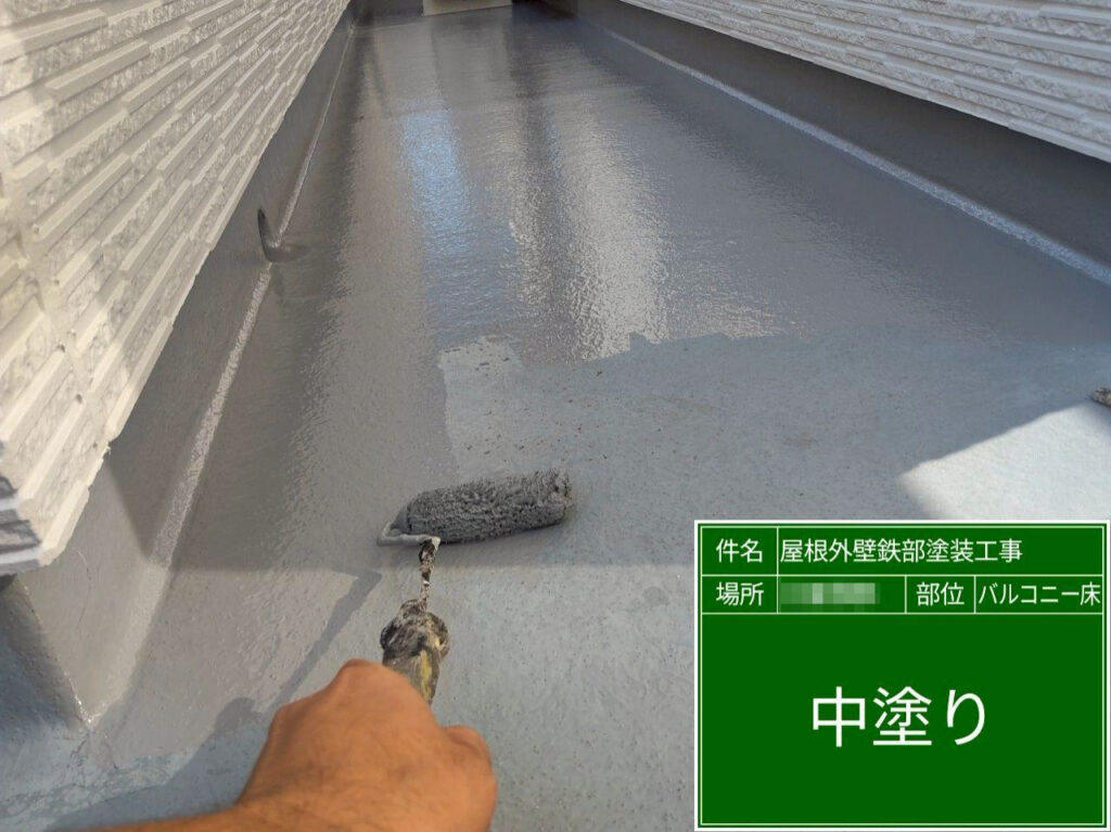 下地調整完了後、中塗り（トップコート1層目）を施工します。塗りムラが出ないよう塗布量を管理し、立上りや入隅まで均一に塗り込みます。