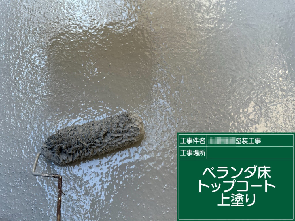 仕上げにベランダ床トップコート上塗り（グレー系／2層目）を行い、表面を均一な艶と膜厚に整えて耐候性・防水性を高めます。