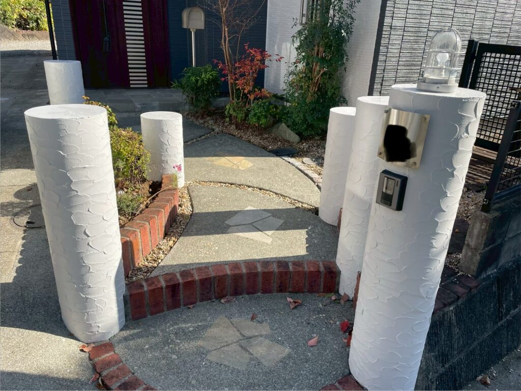 玄関まわりの施工後です。外壁と付帯部のコントラストがはっきりし、アプローチ周辺も明るく清潔感のある印象に。全体の統一感が出ています。