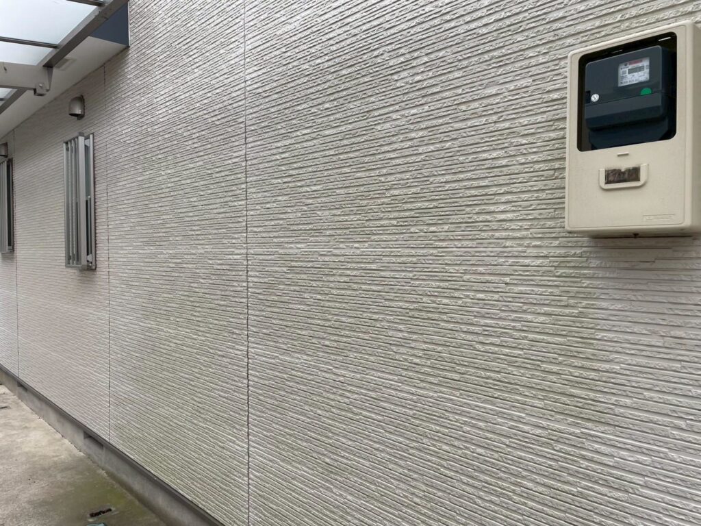 外壁面にコケ汚れや黒ずみが付着している状態です。高圧洗浄で下地を整え、塗料の密着性を高めます。