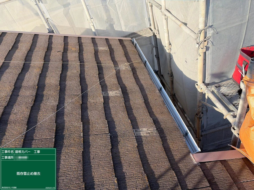 既存の雪止め金具を撤去している様子です。屋根材を傷めないよう丁寧に外し、新しい屋根材に合わせて雪止めを再設置します。