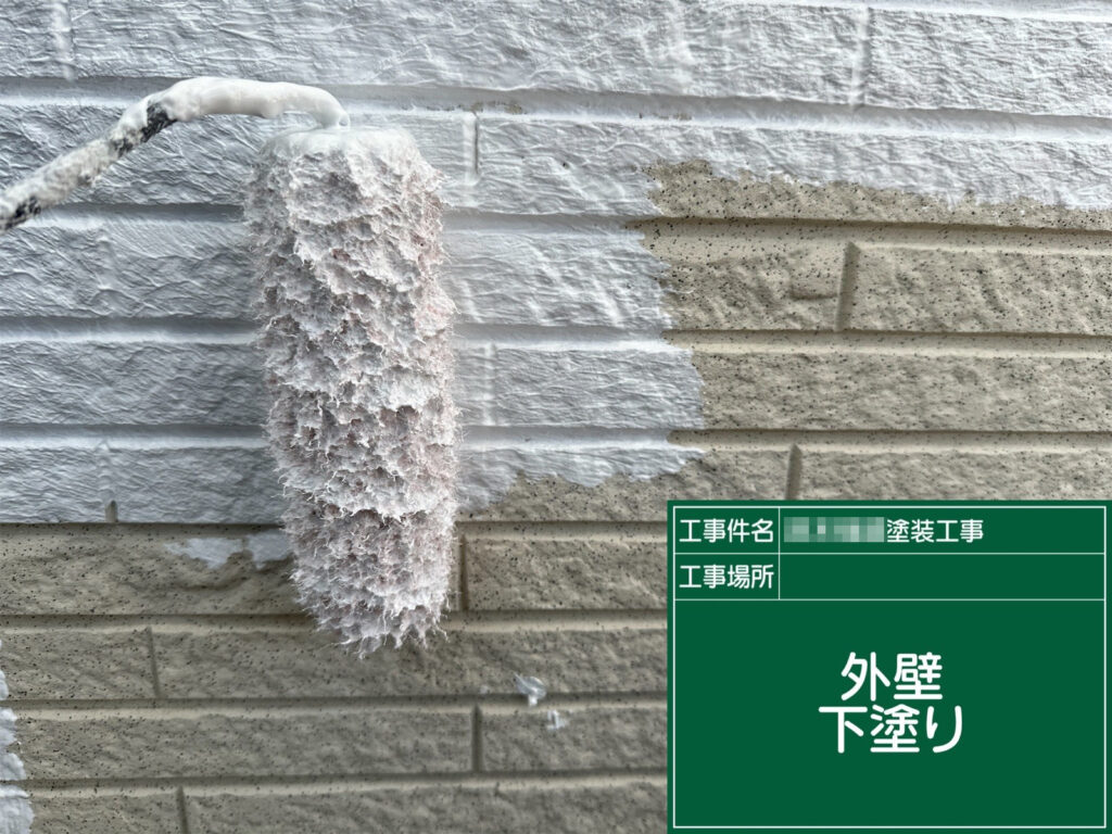 外壁の下塗り工程です。下地を固めて吸い込みを抑え、超低汚染塗料の性能を活かせるよう密着性の土台を作ります。