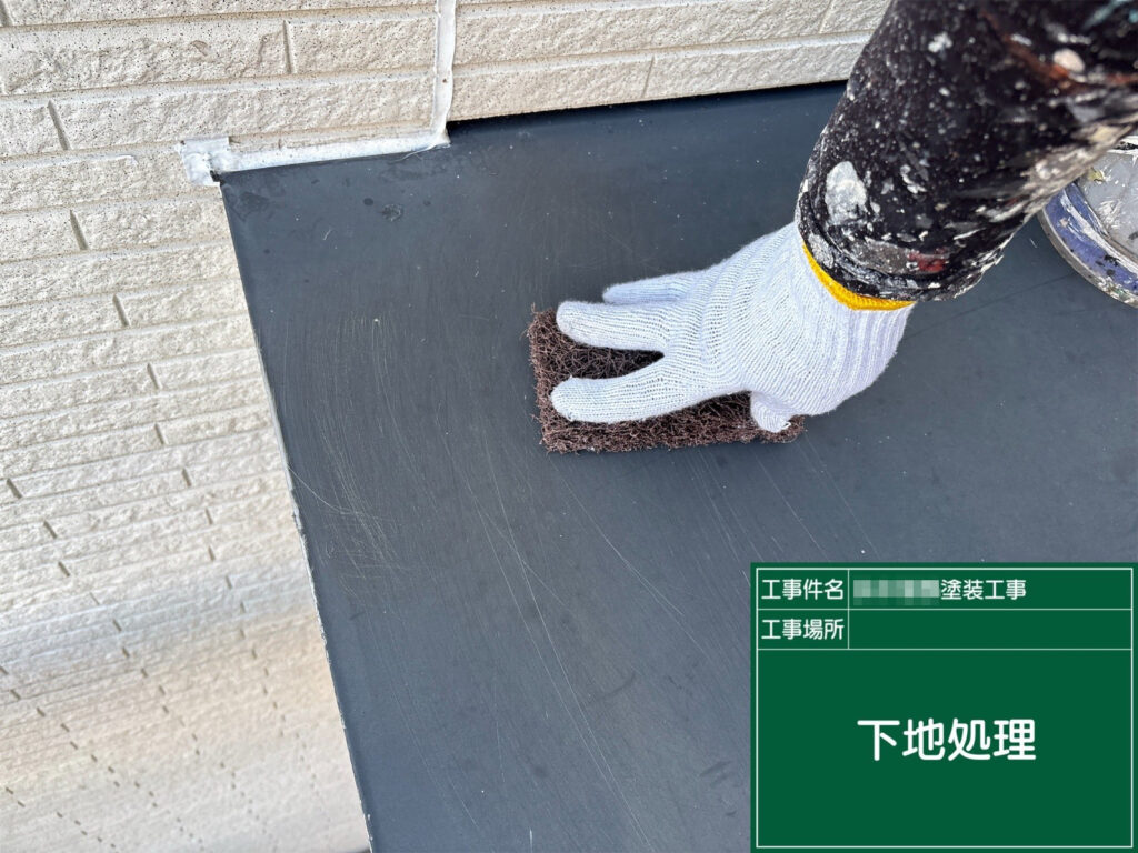 霧除け（板金部）の下地処理です。ケレンで汚れや旧塗膜を整え、細かな目荒らしを入れて塗料の密着性を高めます。