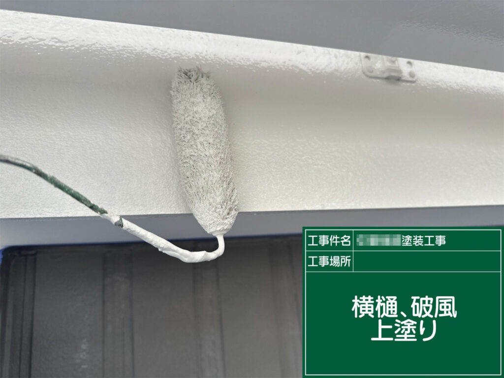 仕上げとなる上塗りを行い、横樋と破風板を美しく整えている様子です。塗膜を均一に仕上げることで、保護性能を高めながら清潔感のある印象に仕上げます。