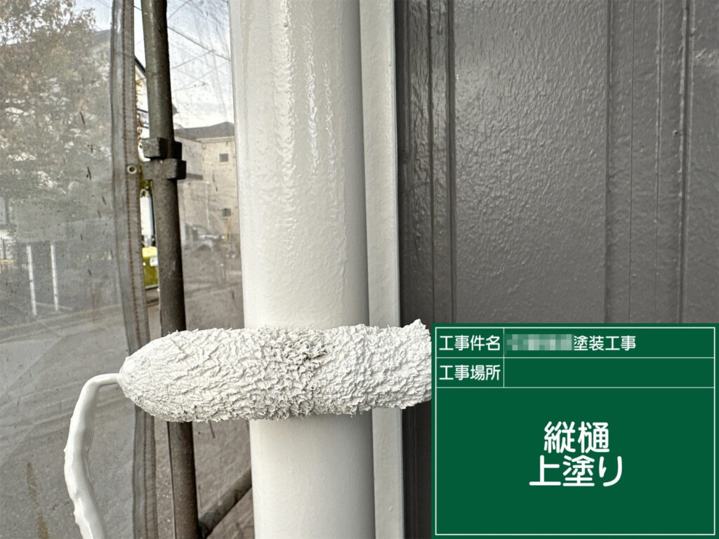 竪樋の上塗りを行い、表面を美しく仕上げている様子です。均一な塗膜を形成することで、見た目の美しさだけでなく保護性能も高めています。