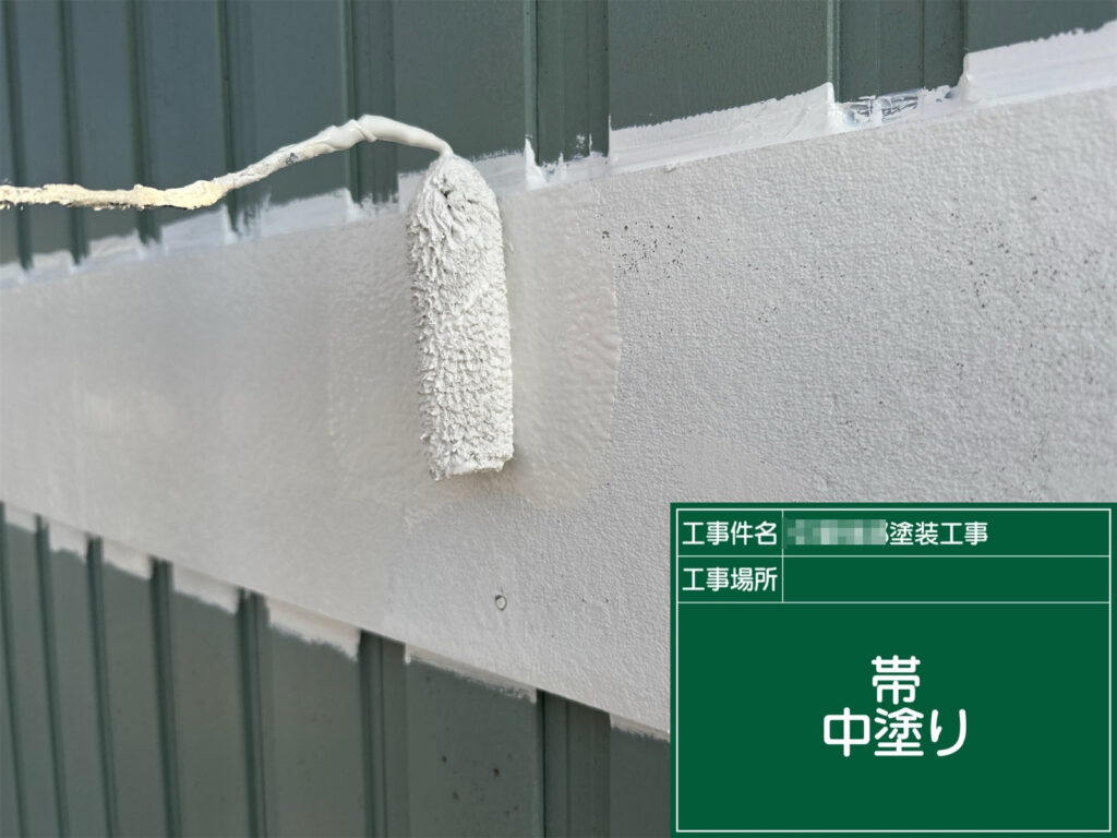 帯部分に中塗りを行っている工程です。塗膜に厚みを持たせながら色ムラを整え、外壁との取り合い部分まで丁寧に塗り進めていきます。