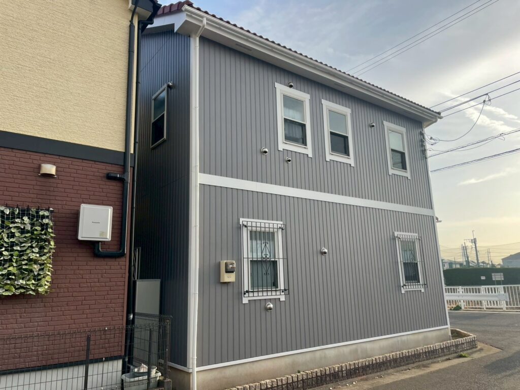 縦ラインの外壁意匠を活かしつつ、全体を美しく整えた施工後の様子です。外壁の色合いと付帯部の白が調和し、上品で統一感のある外観へと生まれ変わりました。