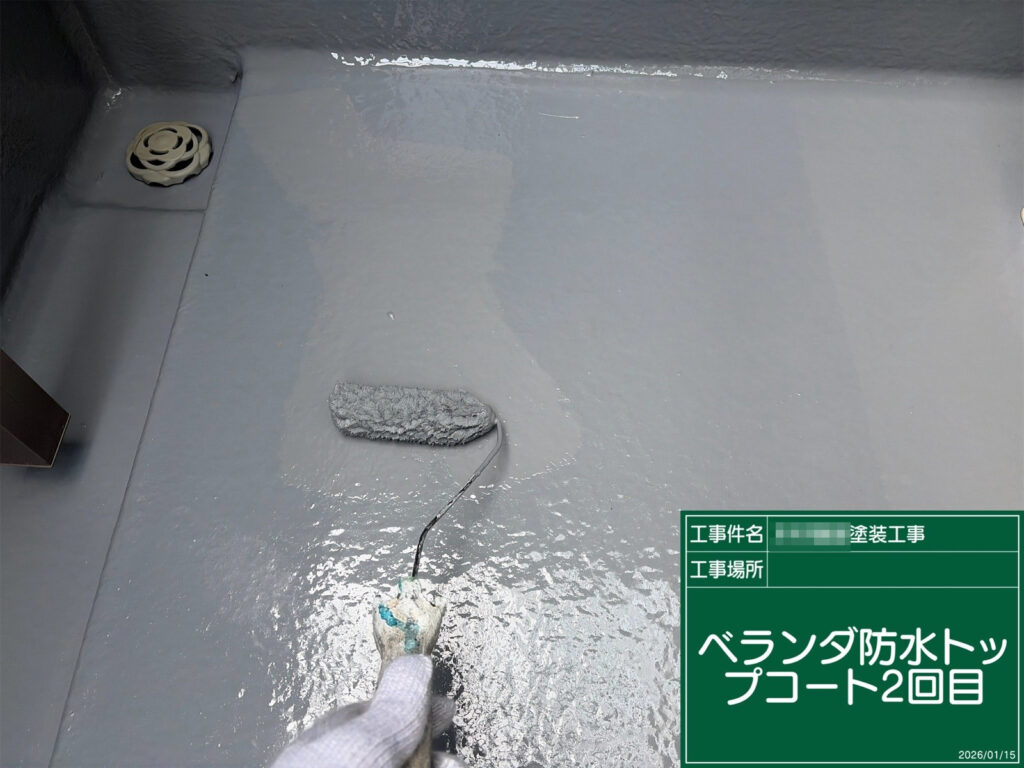 トップコート2回目を重ね、ベランダ床全体をムラなく美しく仕上げていきます。防水層をしっかり保護することで、耐候性と美観の向上につながります。