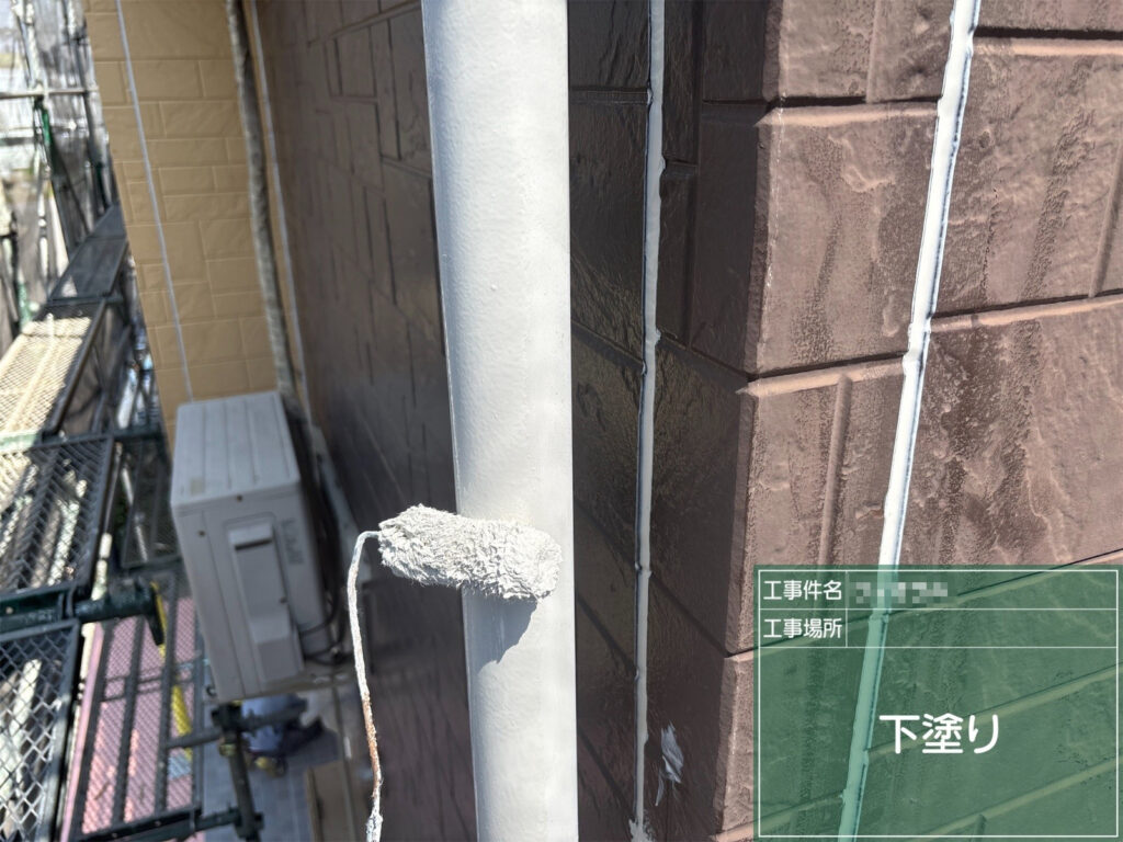 【下塗り｜竪樋】<br />
竪樋に下塗りを行います。塗装面を整え、仕上げ塗料がのりやすい状態にします。