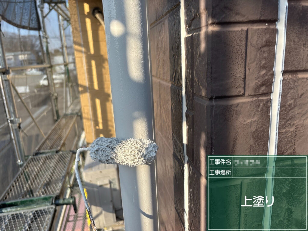 【上塗り｜竪樋】<br />
竪樋に上塗りを行います。紫外線や雨による劣化を抑える塗膜を形成します。