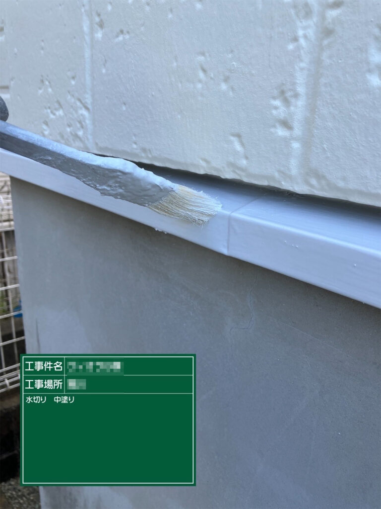 【中塗り｜水切り】<br />
水切りに中塗りを行います。塗膜の厚みを確保し、基礎まわりの金属部を雨水から守ります。
