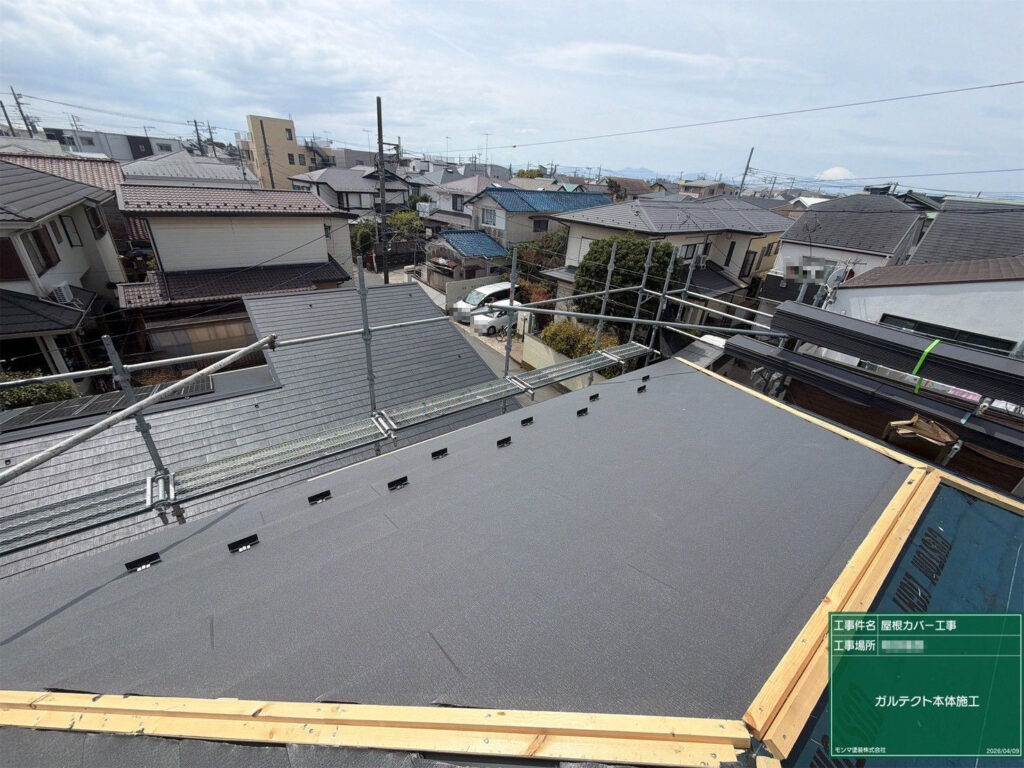 屋根材を一枚ずつ葺き進め、所定の位置へ雪止め金具を取り付けながら、屋根面の並びを合わせます。