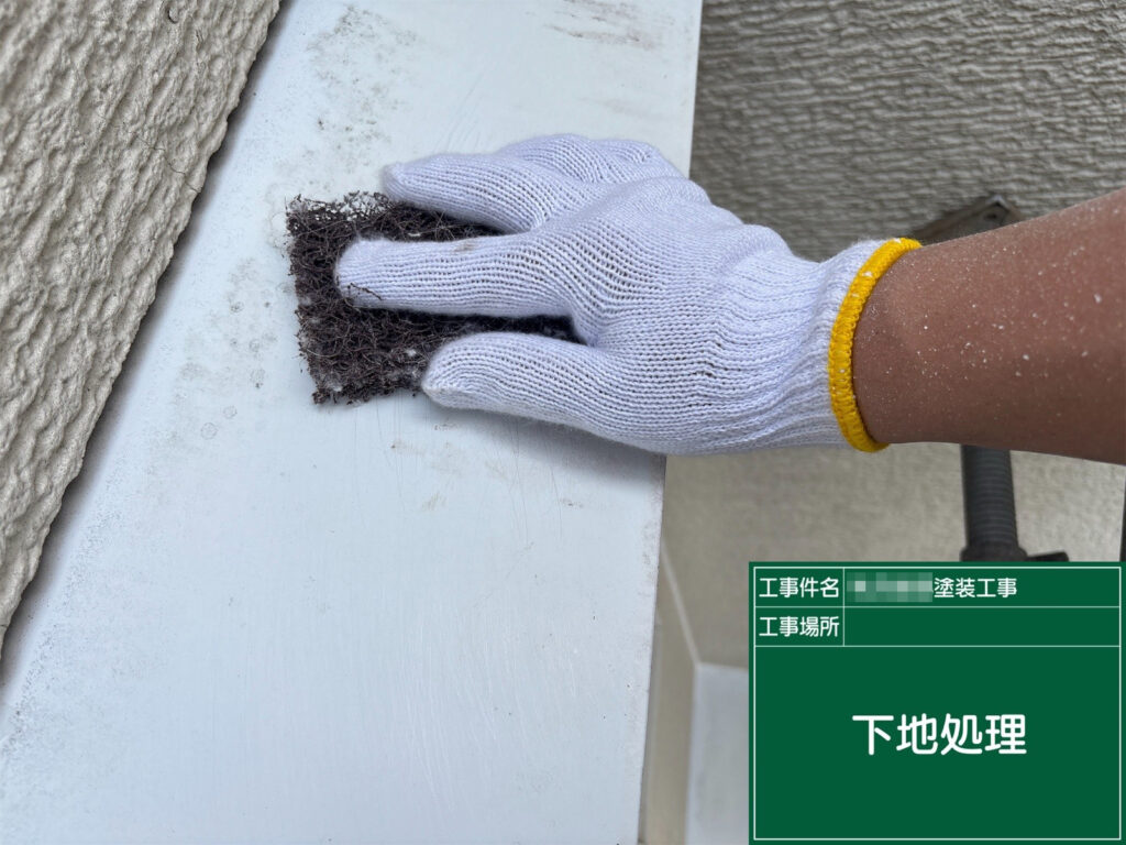 霧除けの表面を丁寧にケレンし、汚れや古い塗膜を取り除きながら、塗装前の下地を整えます。