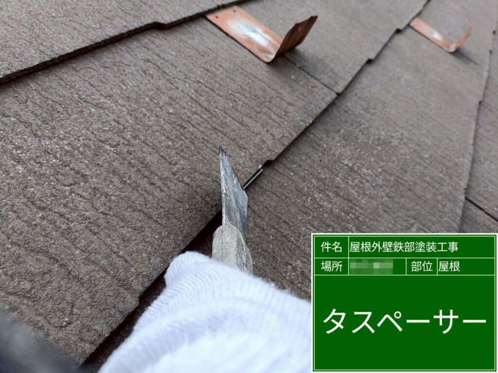 屋根材の重なり部分にタスペーサーを差し込み、塗装後も適切な隙間を確保できるようにします。